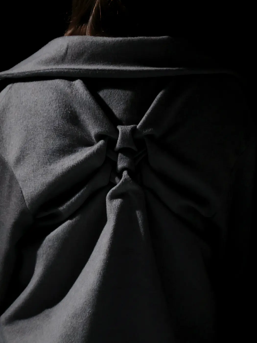 Dos du manteau gris noué, gros plan