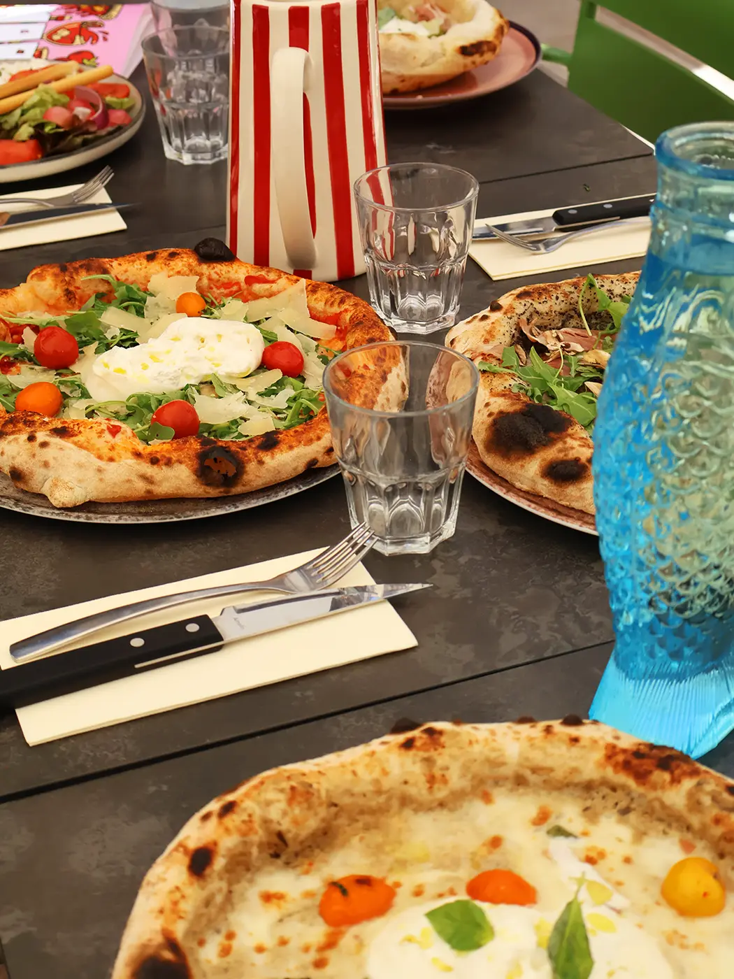 Pizzas et carafe en forme de poisson sur la table