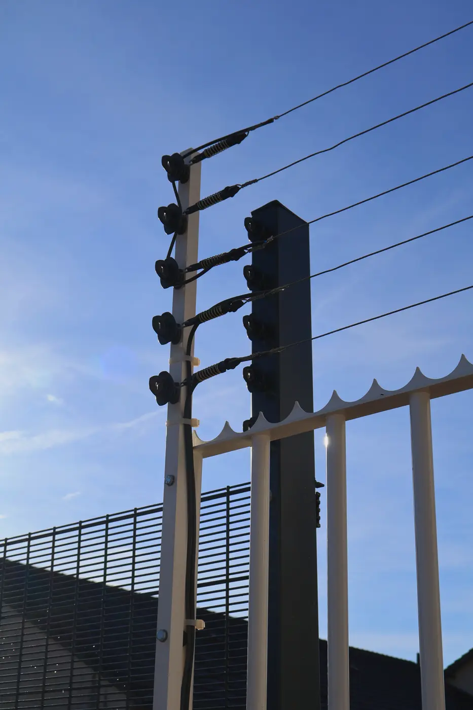 Poteaux de clôture électrifiée au-dessus d’une grille