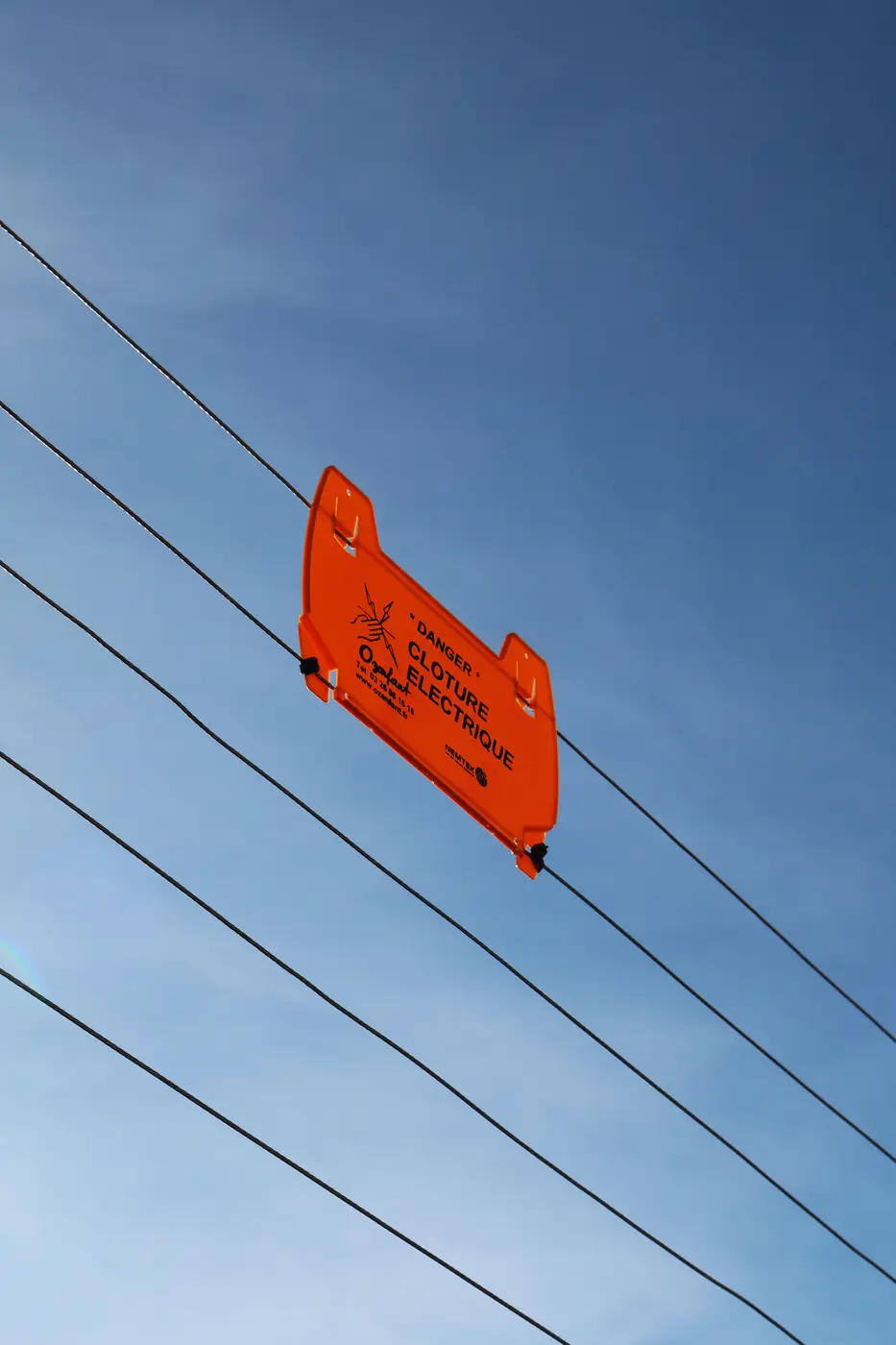 Plaque d’avertissement sur une clôture électrifiée
